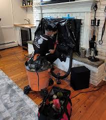 Vacuum and cleaning equipment on protective coverings in front of a fireplace